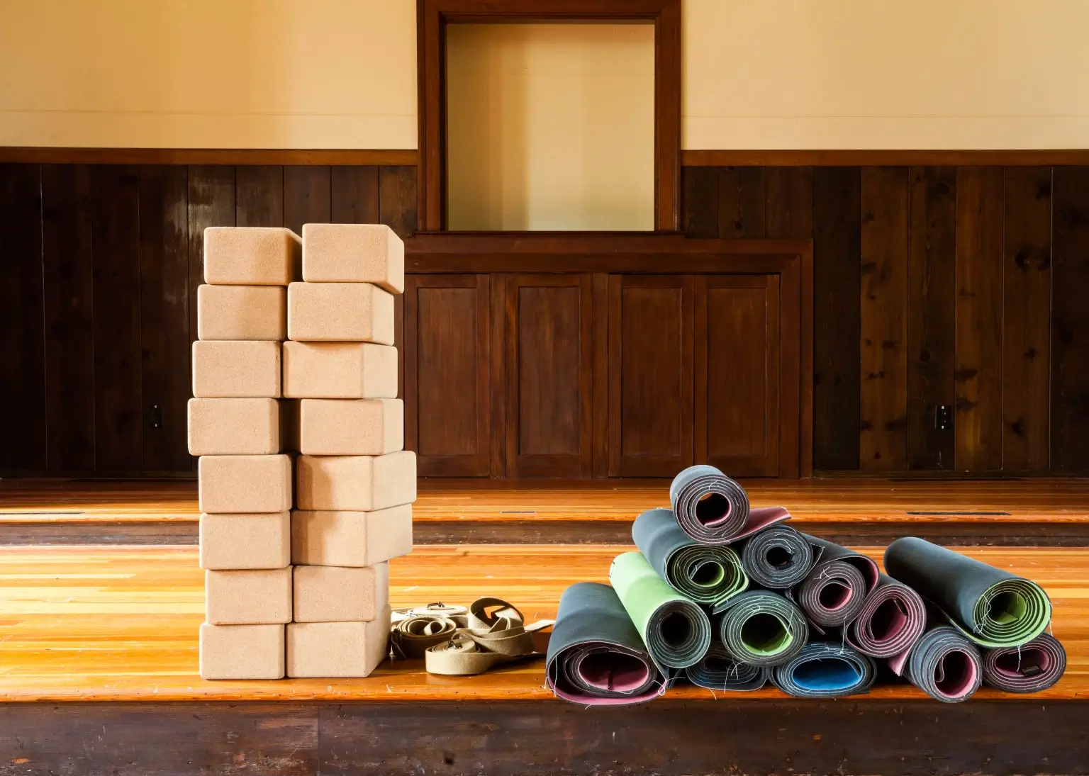 Neatly stacked yoga blocks and props.